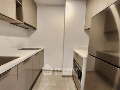 Modern kitchen with sleek cabinetry and stainless steel appliances in a compact layout.