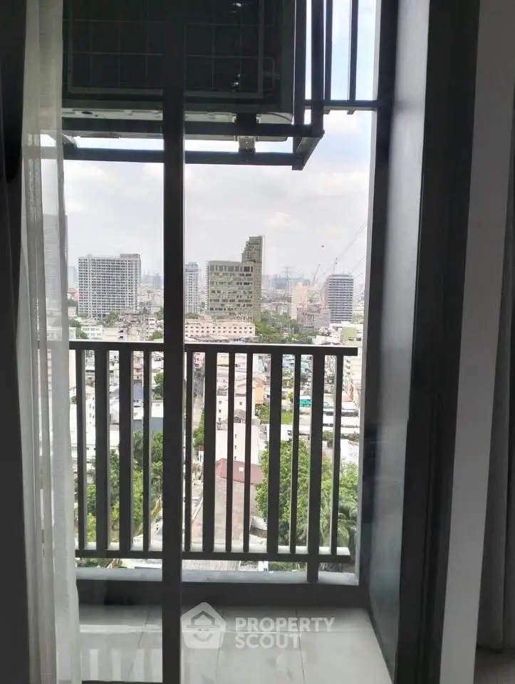 Stunning city view from a modern apartment balcony with glass railing.