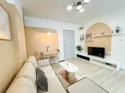 Modern living room with beige sofa, stylish decor, and cozy dining area
