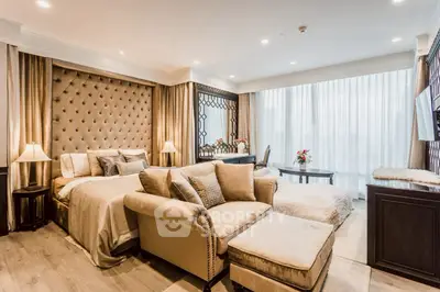 Luxurious bedroom with elegant decor and plush furnishings, featuring a cozy seating area and large windows.