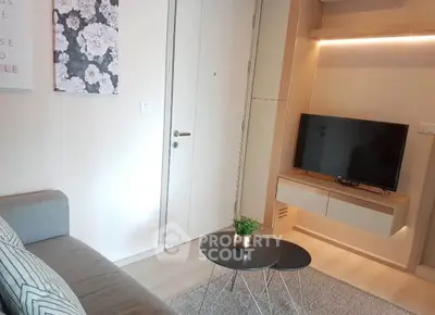Modern living room with sleek TV unit and cozy seating area, perfect for relaxation.