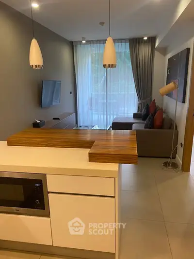 Modern open-plan kitchen and living room with stylish decor and natural light.