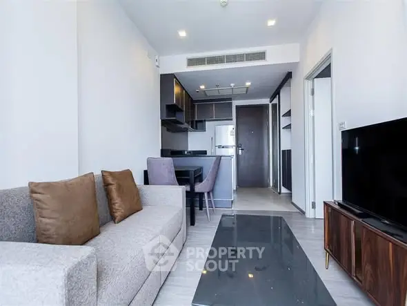 Modern living room with open kitchen layout and stylish furniture