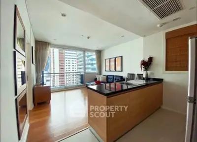 Modern open-layout kitchen and living room with city view and stylish decor.