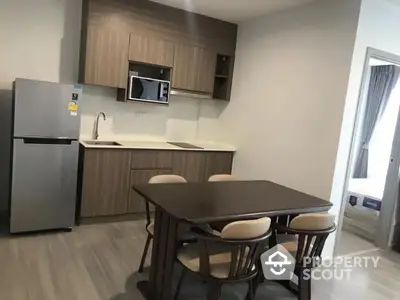 Modern kitchen with dining area featuring sleek cabinetry and contemporary appliances