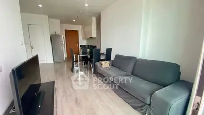 Modern living room with sleek furniture and open kitchen layout in a stylish apartment.