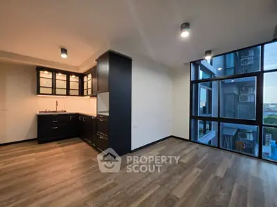 Modern apartment interior with sleek kitchen and large windows offering stunning city views.