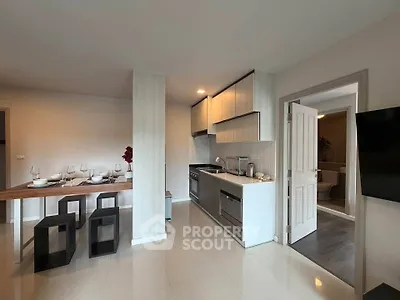 Modern kitchen with dining area featuring sleek cabinetry and elegant table setting.