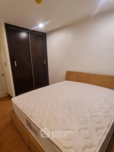 Cozy bedroom with a comfortable bed and spacious wardrobe in a modern apartment.