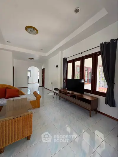 Spacious living room with modern decor and large windows for natural light.