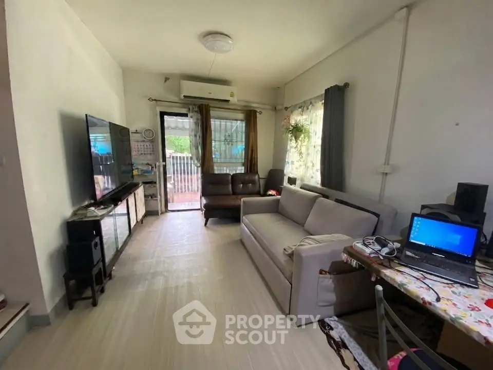 Cozy living room with modern furniture and natural light, ideal for relaxation and entertainment.