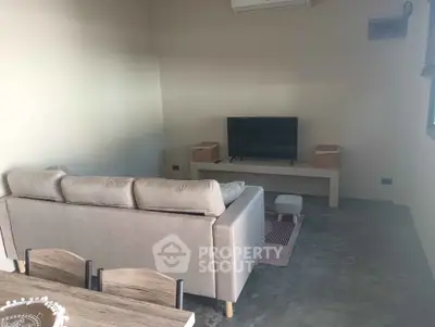 Cozy living room with modern sofa and TV setup, perfect for relaxation and entertainment.