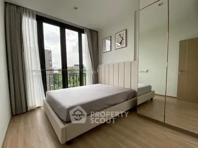 Modern bedroom with large windows and stylish decor in a contemporary apartment.