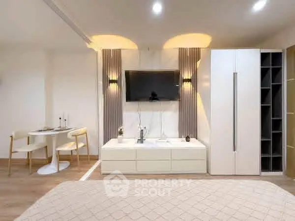 Modern studio apartment with sleek furniture and wall-mounted TV