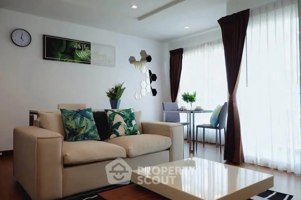 Modern living room with stylish decor and natural light, featuring a cozy sofa and dining area.