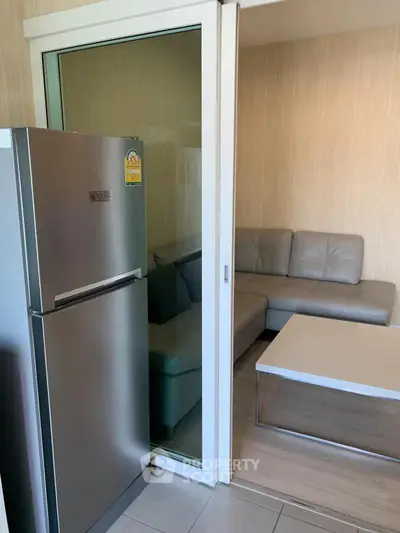 Modern living room with sliding glass door and sleek refrigerator