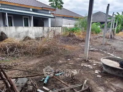 Vacant land with potential for development in a residential area, featuring nearby houses and open space.
