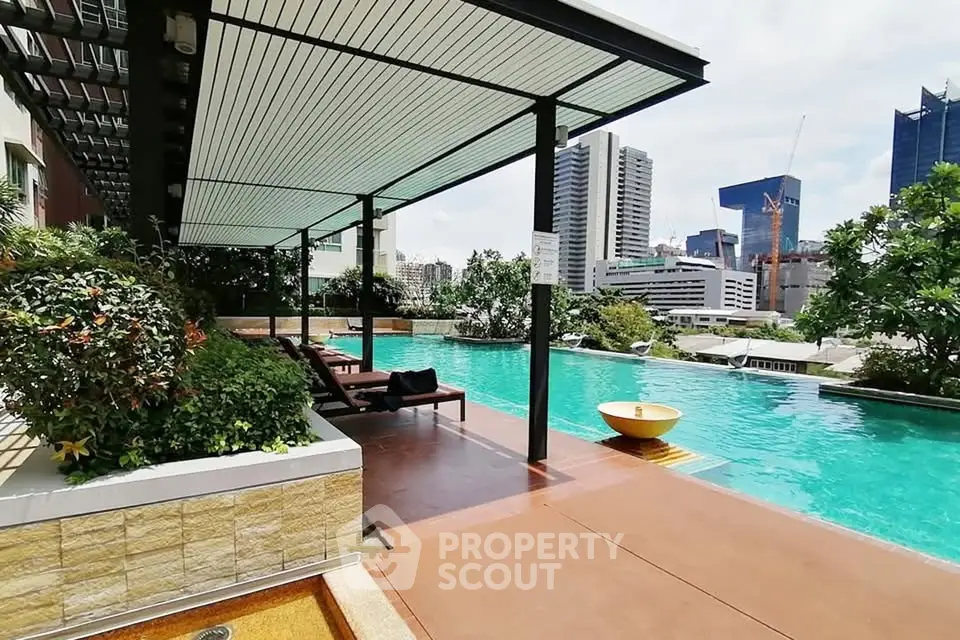 Luxurious rooftop pool with city skyline view in modern apartment complex.