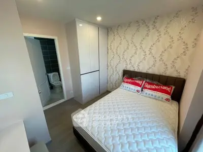 Modern bedroom with stylish wallpaper and ensuite bathroom in a cozy apartment.