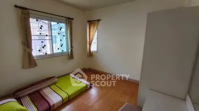 Cozy minimalist bedroom with wooden flooring and natural light