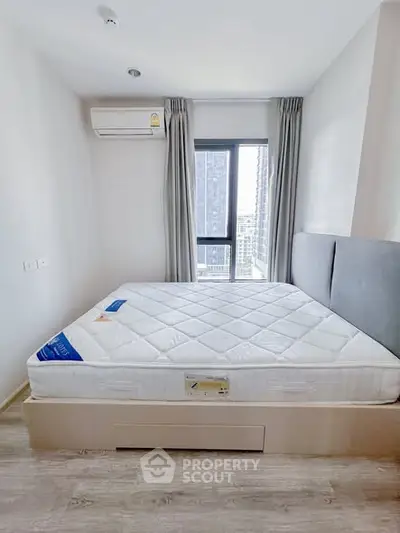 Modern bedroom with large window and air conditioning in a high-rise apartment.