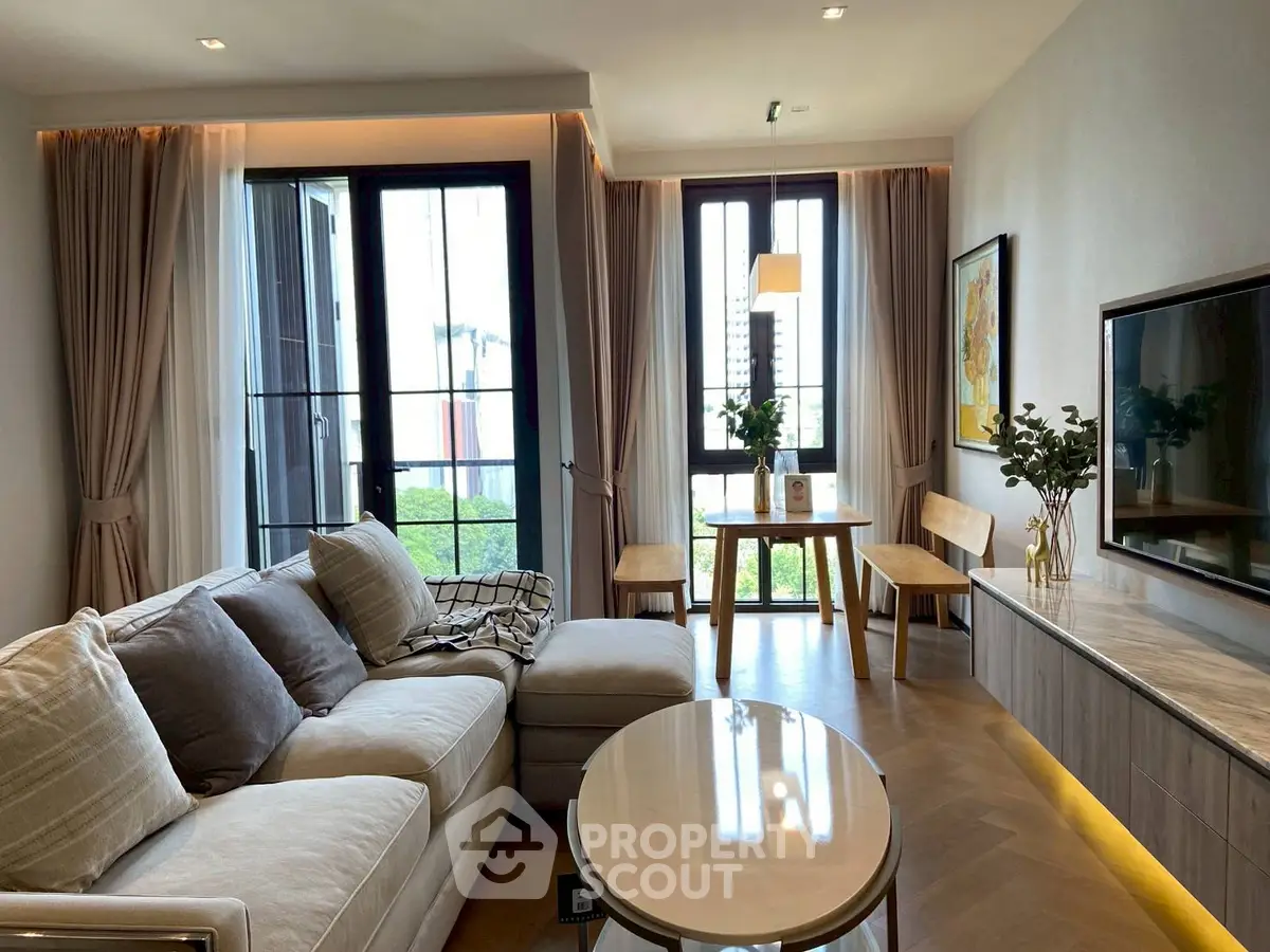 Elegant living room with modern decor and large windows offering natural light