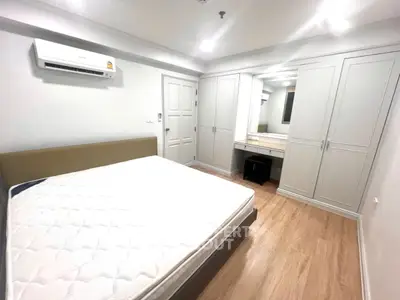 Spacious bedroom with modern furnishings and ample storage in a stylish apartment.
