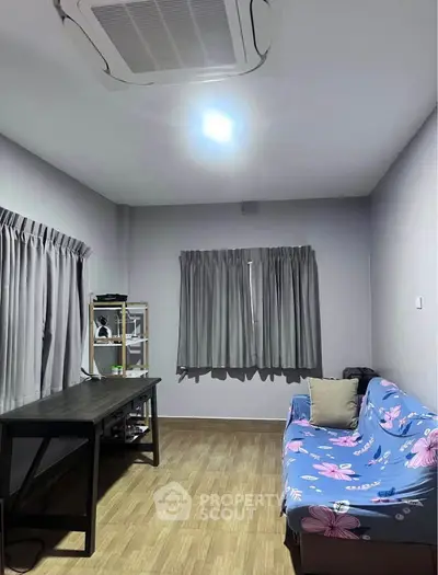 Cozy living room with floral sofa and modern desk, perfect for relaxation and work.