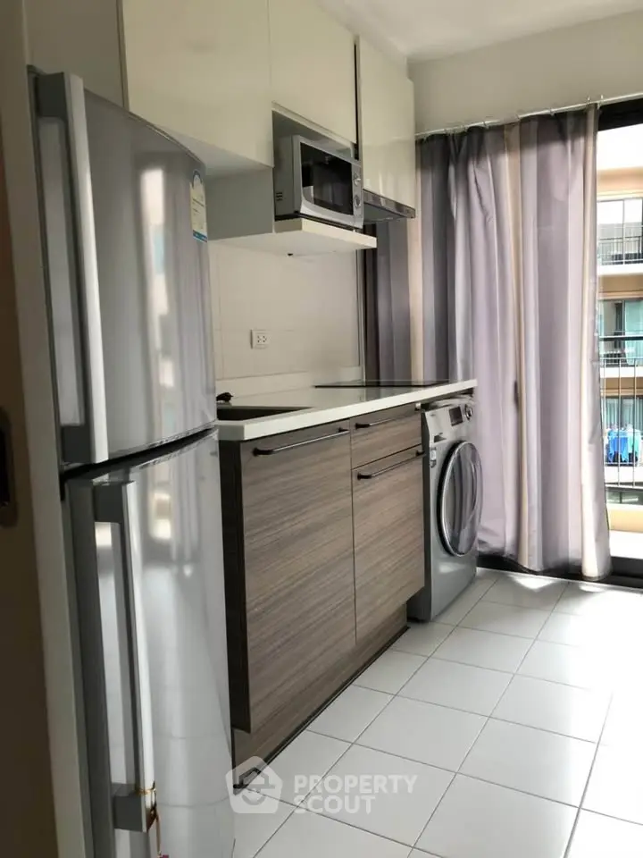 Modern kitchen with sleek appliances and natural light in a stylish apartment.