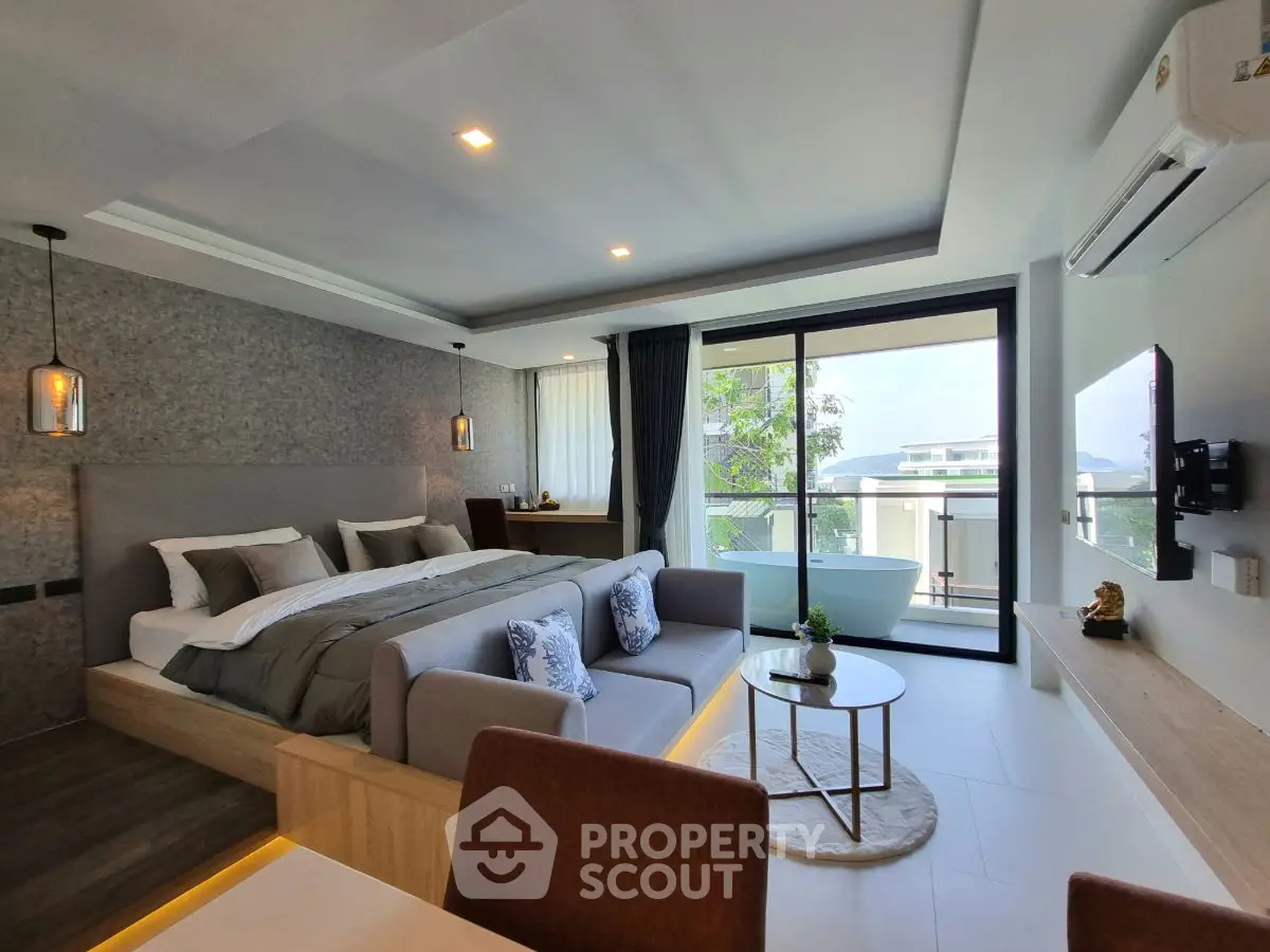 Luxurious bedroom with modern decor and balcony view, featuring a cozy seating area and stylish lighting.