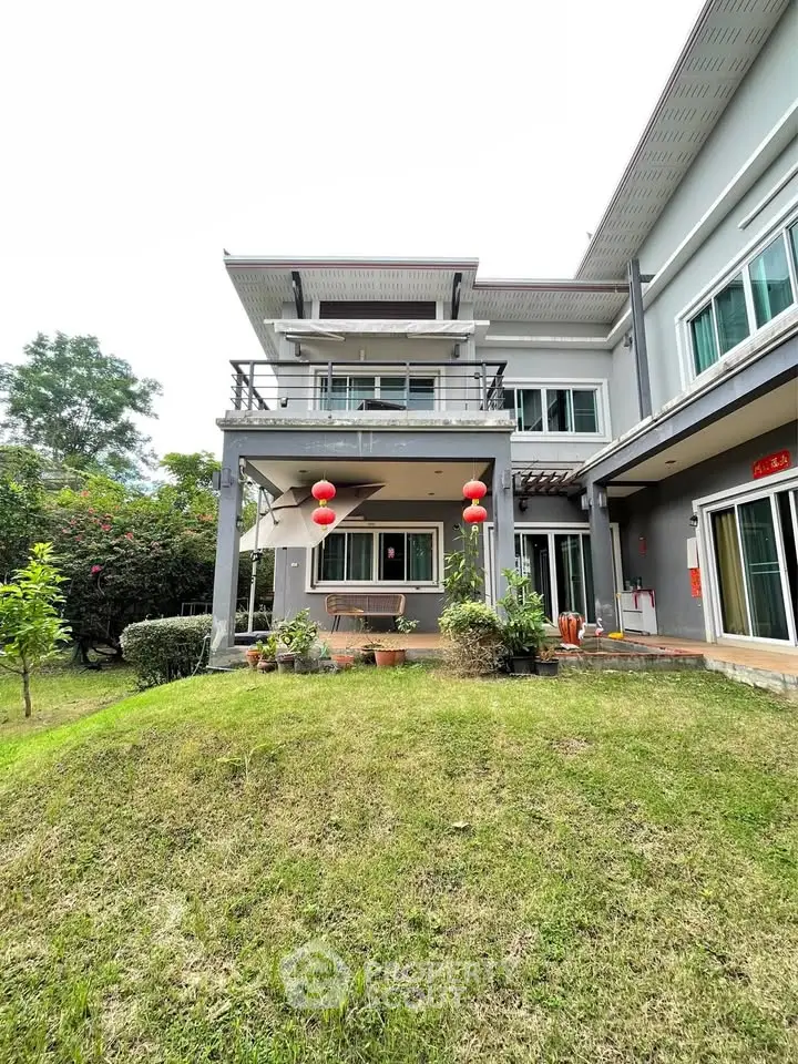 Elegant two-story house with lush garden and balcony, perfect for family living.