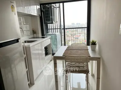 Modern kitchen with sleek design and city view, featuring compact dining area and large window.