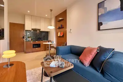 Modern living room with stylish decor and compact kitchen in open layout apartment.