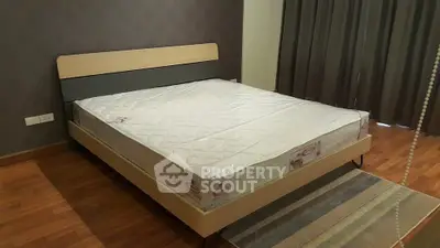 Spacious bedroom with modern bed and hardwood flooring, perfect for comfort and style.