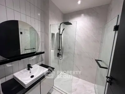 Modern bathroom with sleek shower and stylish sink in contemporary design.