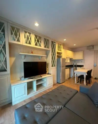 Spacious living room with elegant built-in cabinets and modern kitchen in open layout.