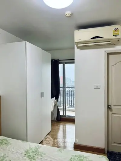 Cozy bedroom with balcony access and air conditioning in modern apartment.