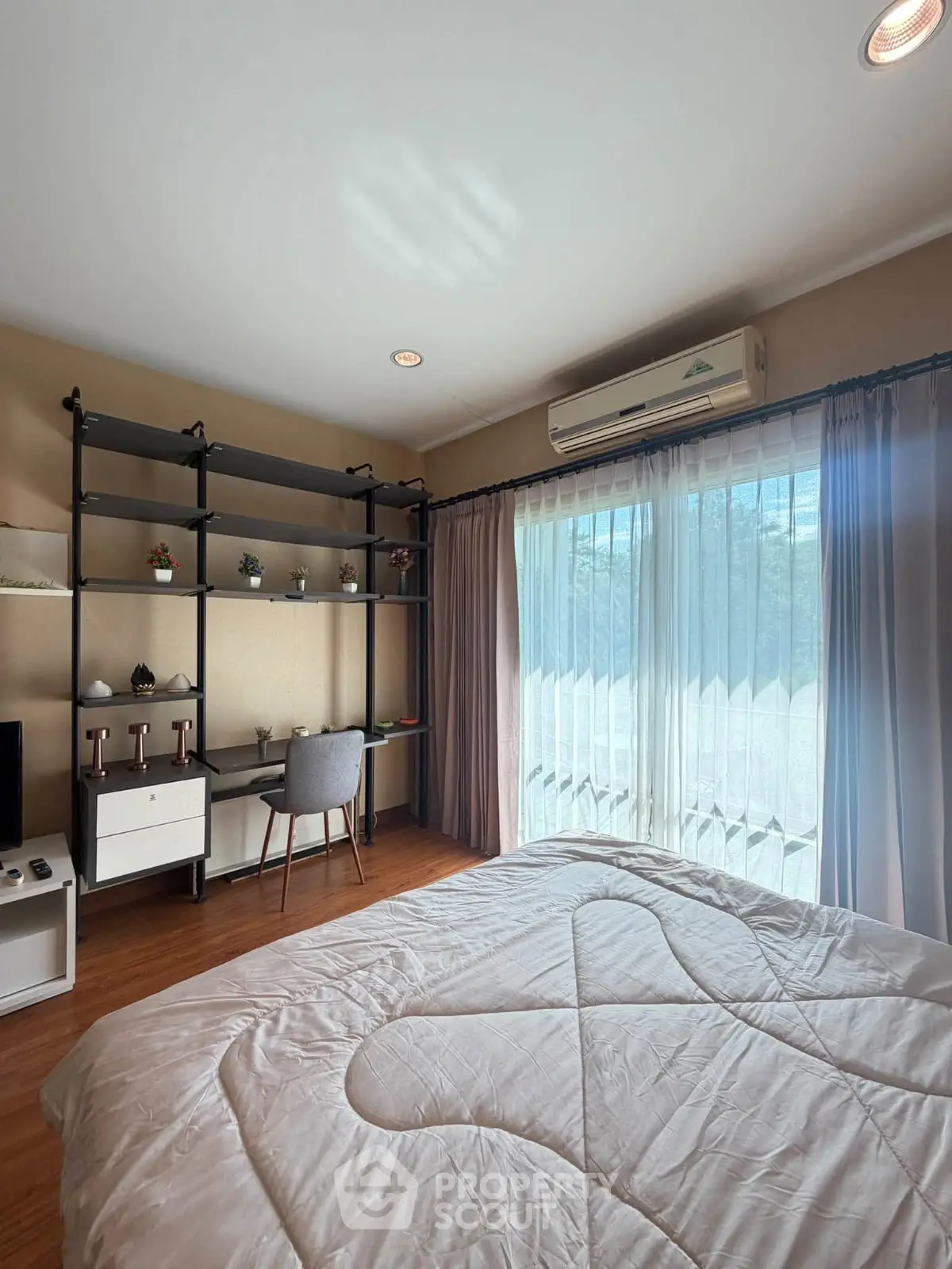 Cozy bedroom with large window, modern desk, and stylish shelving, perfect for a serene living space.