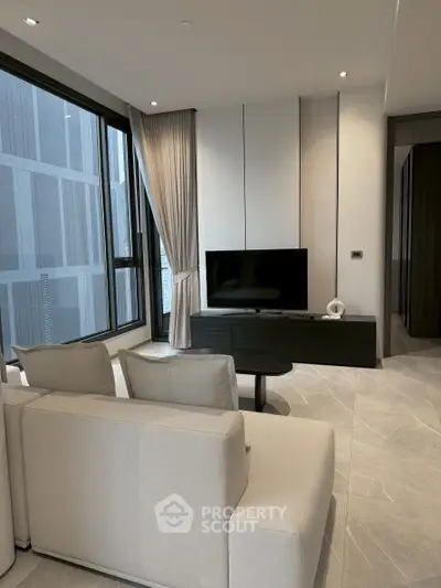 Modern living room with sleek design and large windows offering city views.