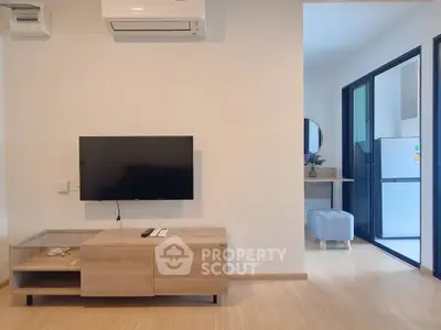 Modern living room with wall-mounted TV and air conditioning, featuring sleek wooden furniture and bright natural lighting.