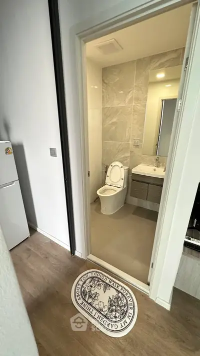 Modern bathroom with sleek design and adjacent kitchen area in a contemporary apartment.