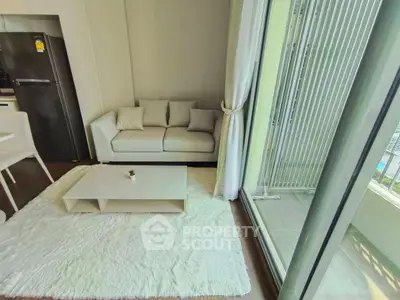 Modern living room with white sofa, plush rug, and balcony view in a stylish apartment.