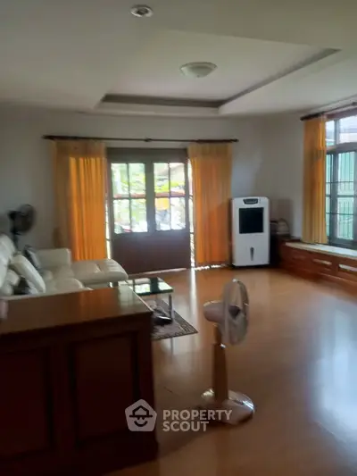 Spacious living room with natural light and modern furnishings