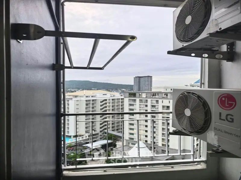 High-rise apartment view with air conditioning units and cityscape in the background.