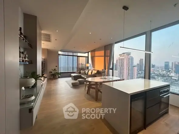 Luxurious open-plan living room with stunning city view and modern kitchen.