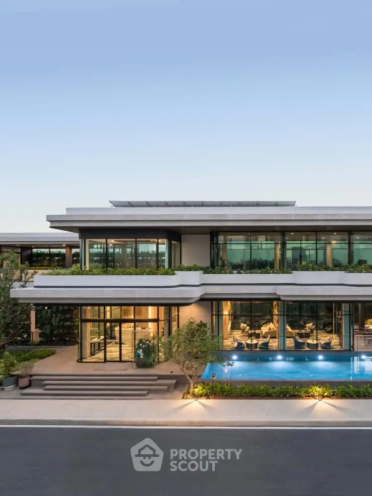 Luxurious modern home with expansive glass windows and a stunning pool, perfect for elegant living.