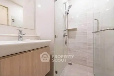 Modern bathroom with sleek shower and stylish vanity in contemporary apartment.