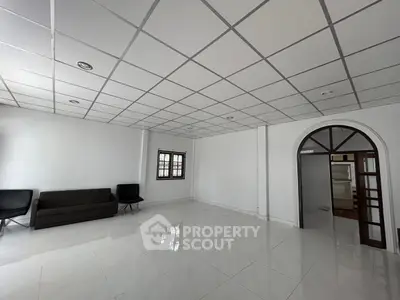 Spacious modern living room with sleek tile flooring and minimalist furniture.