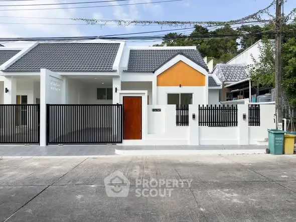 Modern single-story house with sleek design and gated entrance