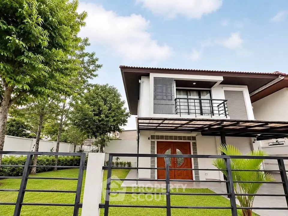 Modern two-story house with lush garden and stylish entrance in a serene neighborhood.